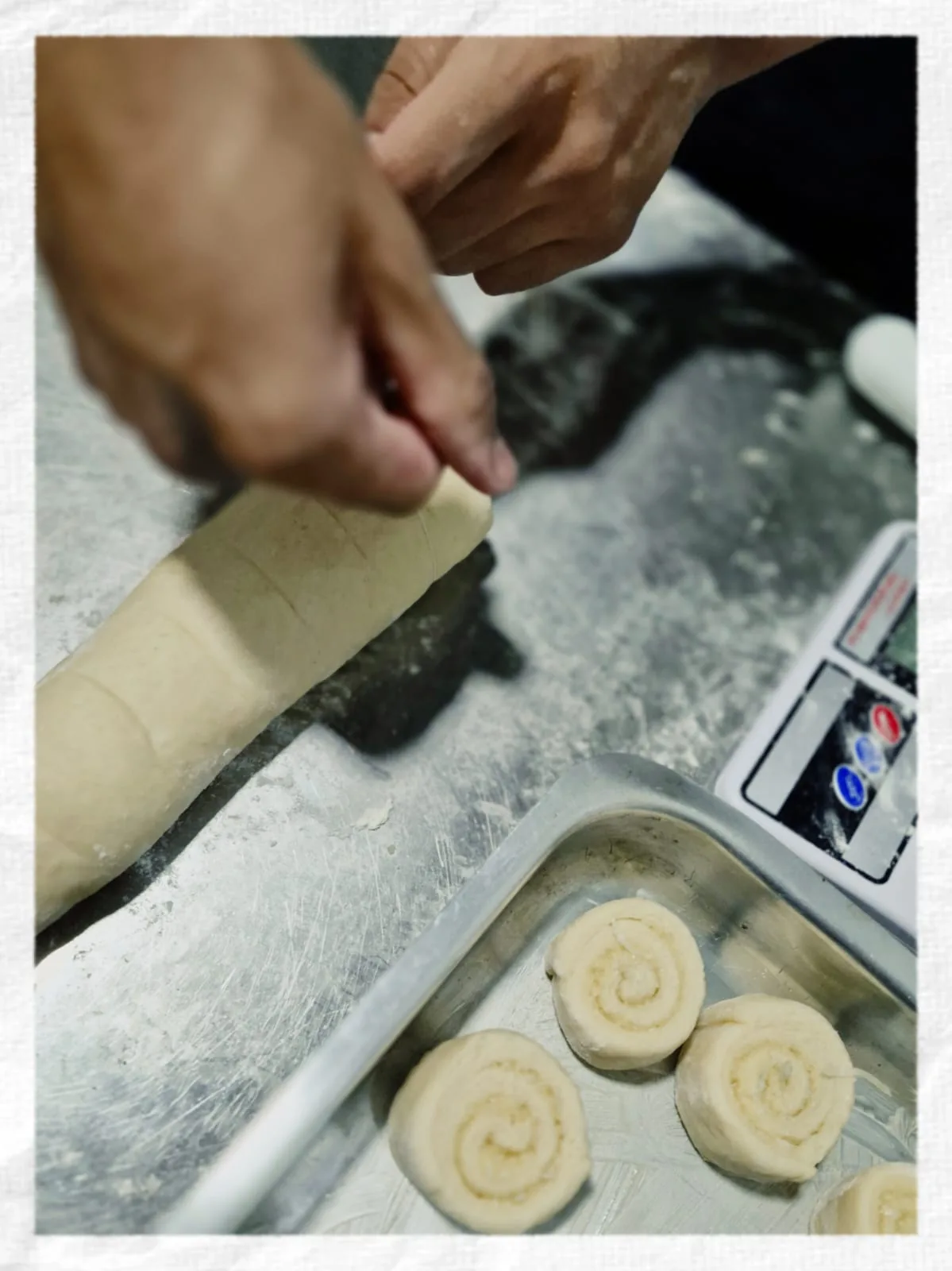 Mãos modelando a massa dos pães sobre a bancada